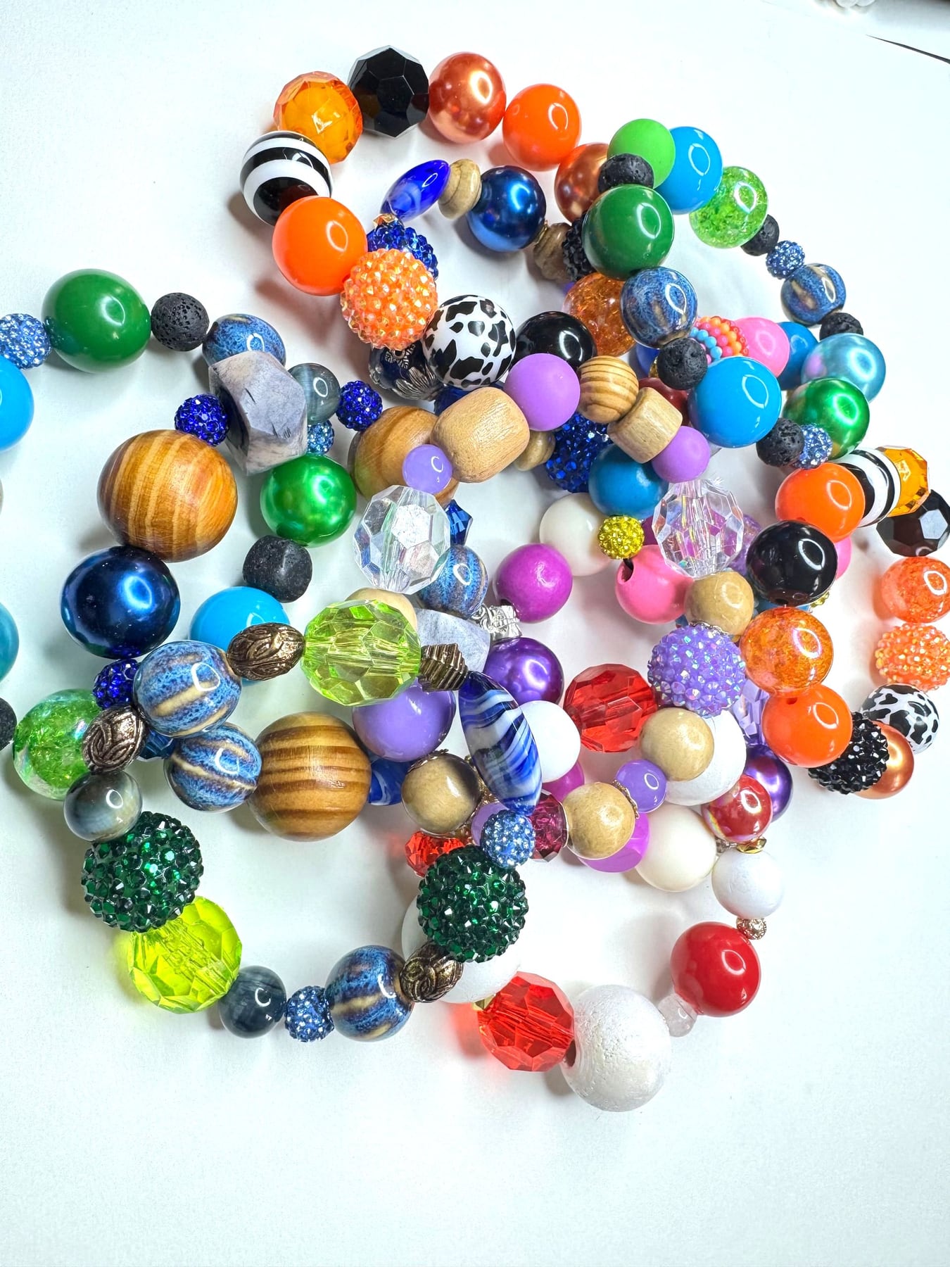 Loose glass and stone beads in every color, ready to be chosen at the bead table
